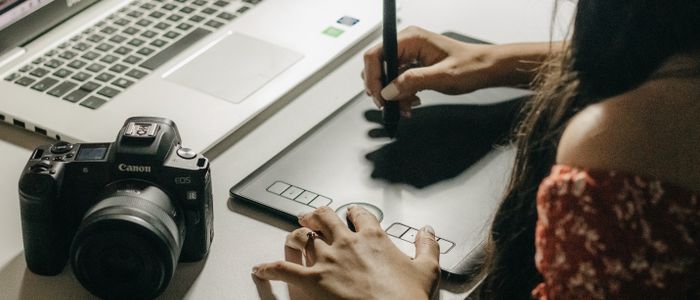 Graphiste indépendante dessinant sur une tablette graphique avec un stylet